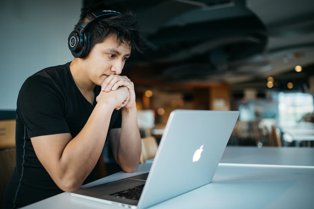 Une personne avec un casque, concentrée devant son ordinateur